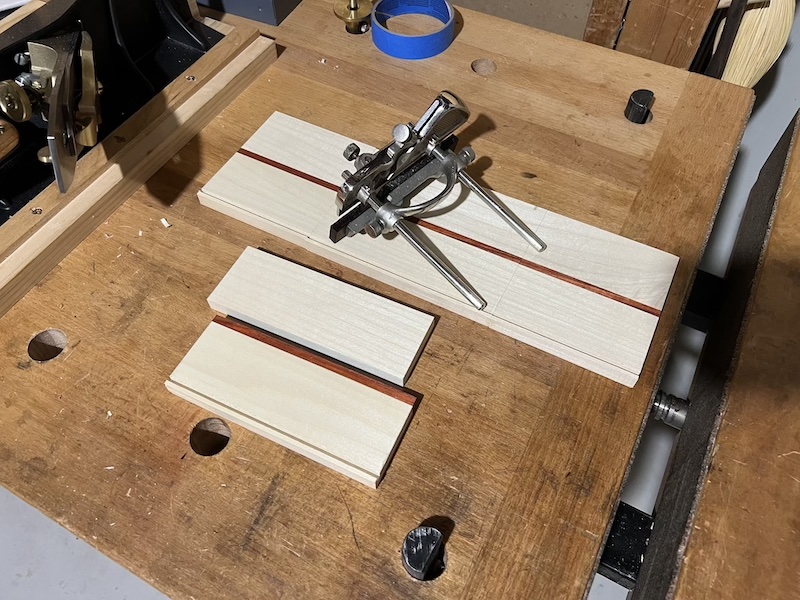 A picture of a Record 043 plane sitting on top of several pieces of poplar with a groove cut on one side.