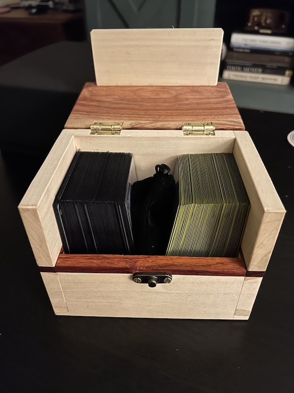 Viewing the inside of the box with two decks of cards and a drawstring bag.