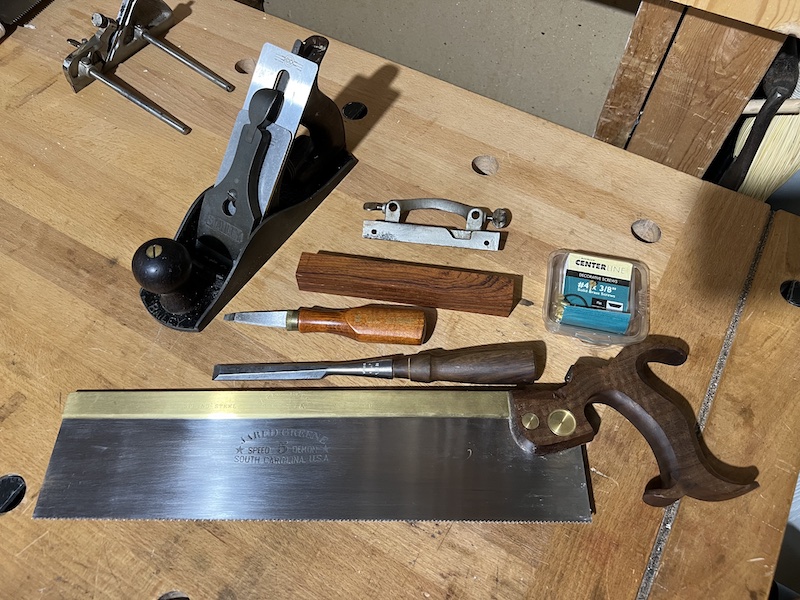 Woodworking tools including a handplane, saw, chisel, and screwdriver on my bench.