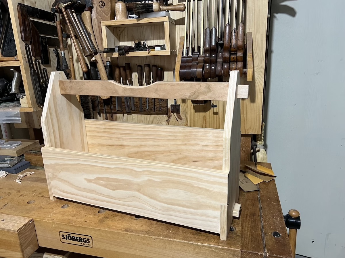 A tool tote as seen from the front shoulder, showing the through-mortise joinery on the end, and the sides with half-lap joinery.